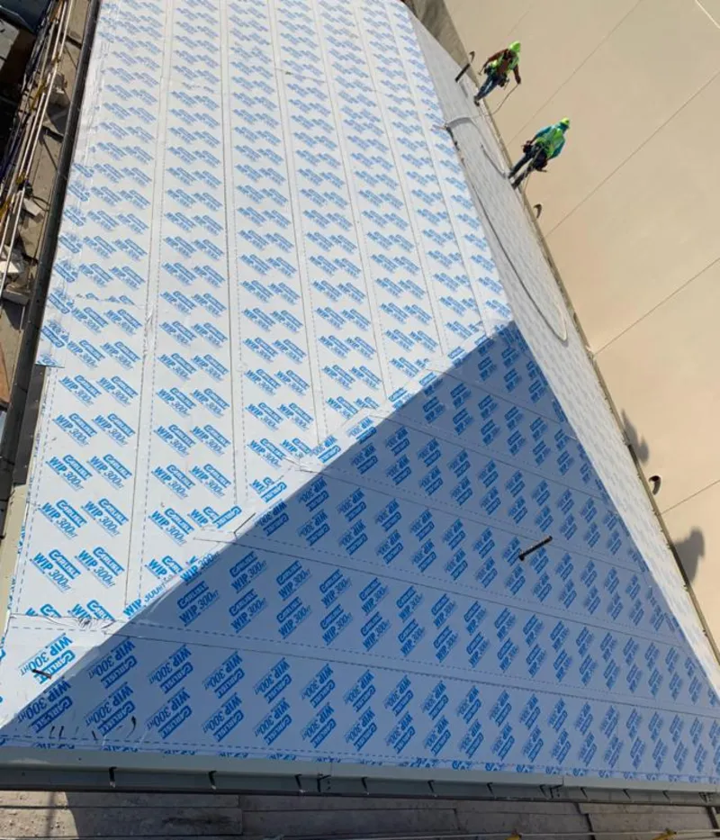 Professional roofers installing underlayment on a metal roof in St. Albans